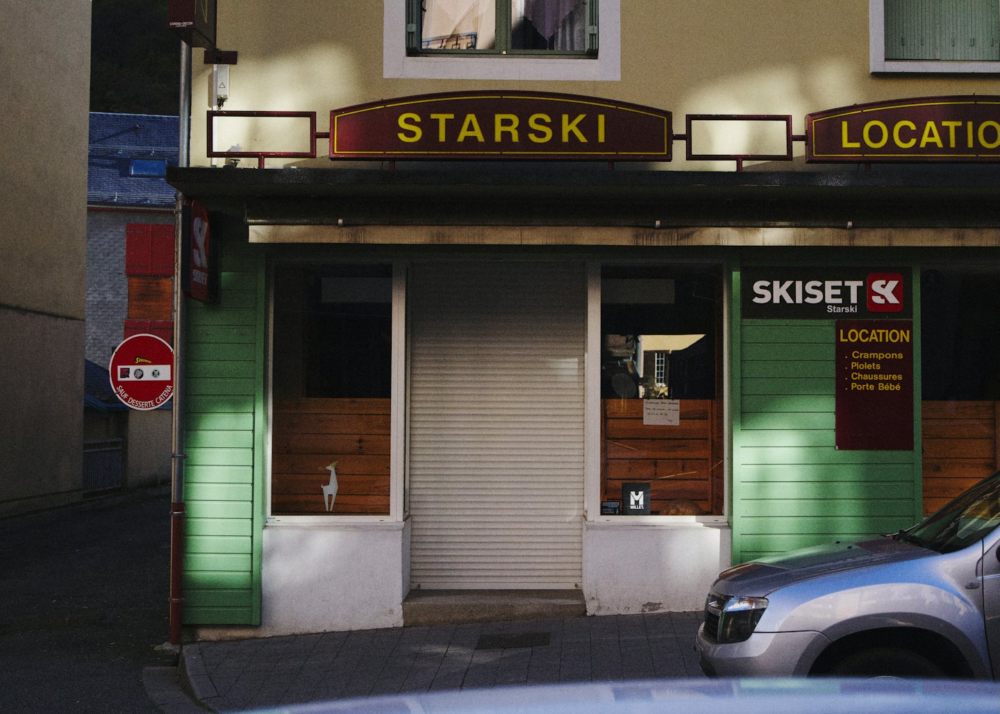 La facciata del negozio di noleggio Starski con un'insegna color vinaccia su una strada.