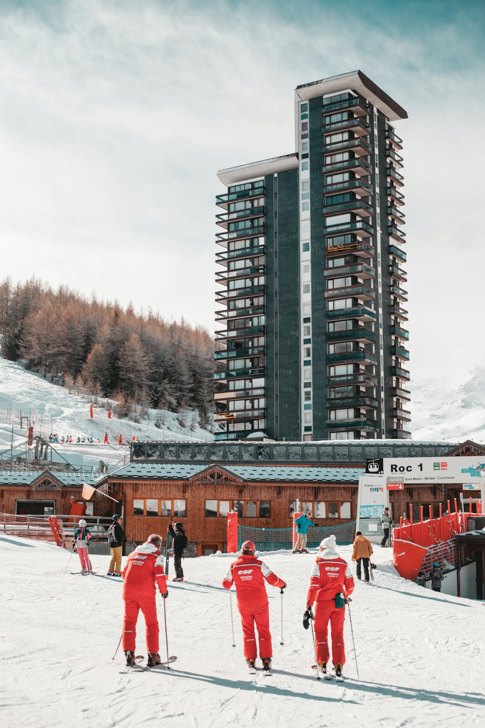 Istruttori di sci in tute rosse su un pendio innevato.
